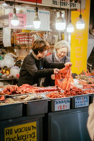 Two locals at a kimchi stand in a market in Seoul, South Korea 