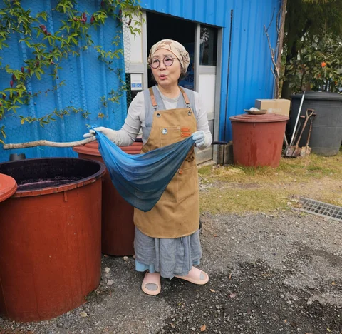 lady holding up a dyed piece of fabric