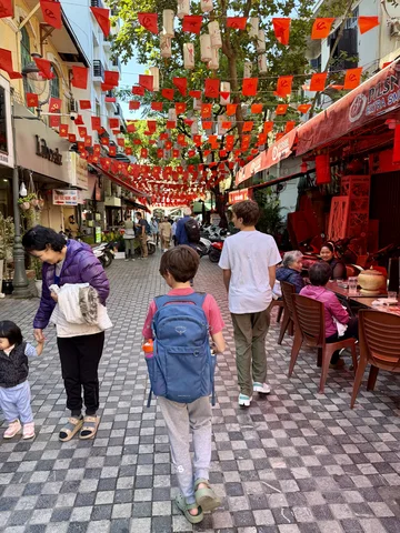 Walking down a street in Hanoi with Vietnamese flags