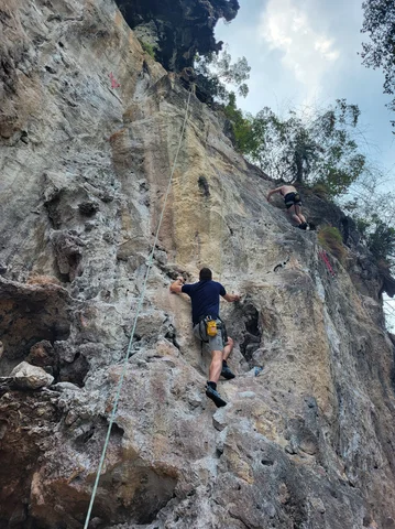 Two men climbing a cliff-face in Krabi