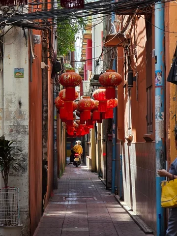 An alleyway between buildings with red silk lanterns