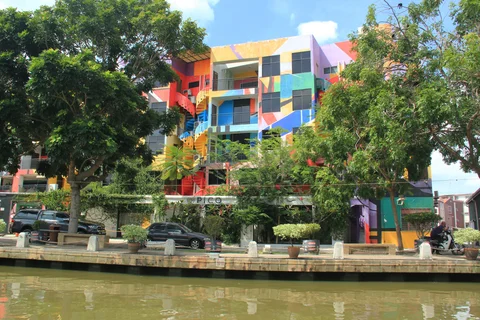 Colourful houses sit along a riverfront