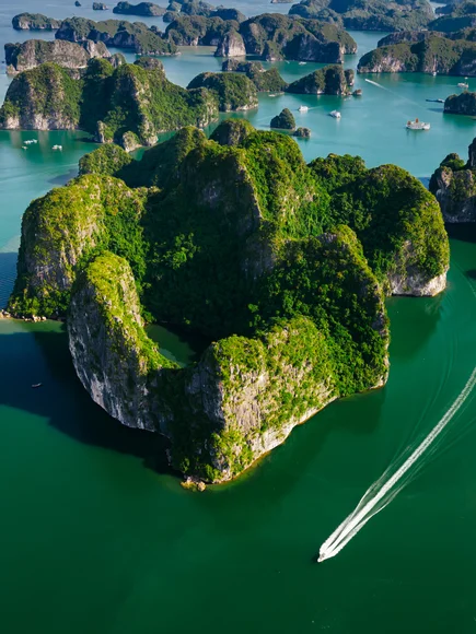 An aerial shot of the karsts of a quieter part of Lan Ha Bay with a boat cruise 