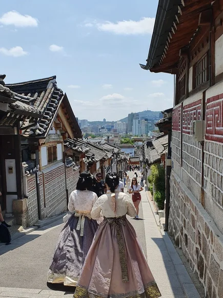 view of bukchon hanok village and two ladies in hanbok