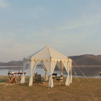 A tent with a dinner table set up by the water on a private safari experience in India in November