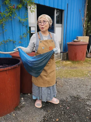 lady holding up a dyed piece of fabric