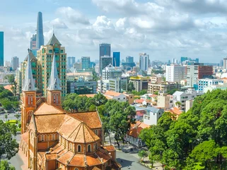 Aerial view of Ho Chi Minh City cathedral, with motorcyclists riding on the streets around it