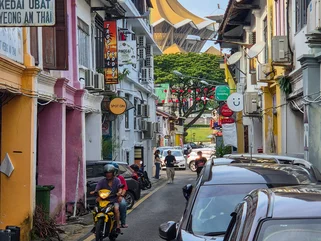 A colourful street in Kuching with a temple in the background
