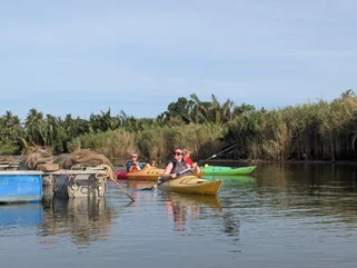 Family of tourists kayaking on a cultural adventure in Southeast Asia with children