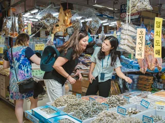 A local Korean guide and a tourist at a fish market in Busan