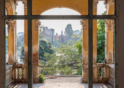 An old brick archway partially painted provides beautiful views of royal palance in Phnom Penh