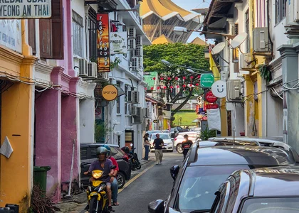 A colourful street in Kuching with a temple in the background