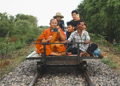 Cambodia Battambang Monk Bamboo Train with a monk taking a photo on his phone