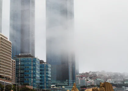 View of Busan beach with sand sculptures with the mist concealing high rise buildings