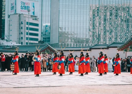 Changing of the guard ceremony in Seoul Palace in front of modern skyscraper buildings