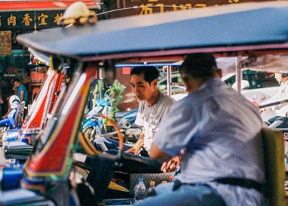 Two men in tuk tuks in Bangkok Thailand