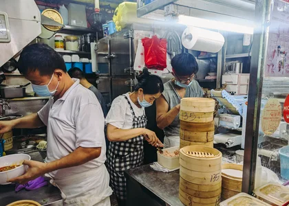 People making dumplings in a hawker market in China town Singapore