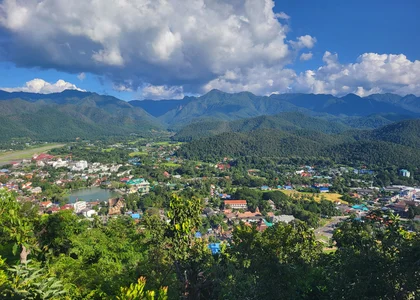Elevated view of a town situated between green mountains