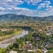 Aerial view of beautiful Luang Prabang city surrounded by jungle and sprawling alongside Nam Khan River