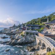 Ornate temple buildings and bridge on the coast with breaking waves