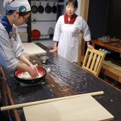 Two people preparing food on kitchen table
