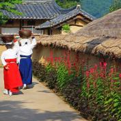 People in traditional dress walking through Hahoe Folk Village