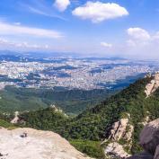 People sitting on rock in Bukhansan National Park overlooking city