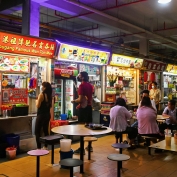 People queuing at food stalls in Singapore Hawker Centre