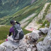 Hiker rests sat down on a rock ledge while staring at the mountainous scenery around the Kamikochi area