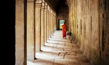 Monk walking under temple arches