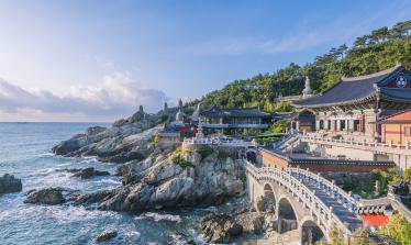 Ornate temple buildings and bridge on the coast with breaking waves