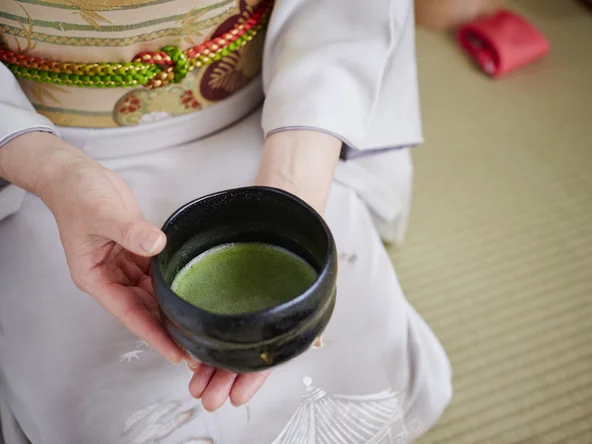 Hands holding cup of green tea 
