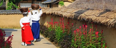 People in traditional dress walking through Hahoe Folk Village 