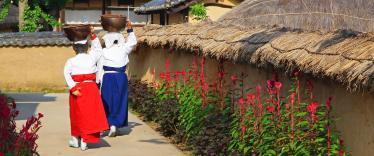 People in traditional dress walking through Hahoe Folk Village 