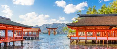 View across water towards Miyajima's red floating torii gate 