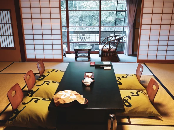 Tatami room with low-lying table and floor cushioned seats has beautiful view of the garden