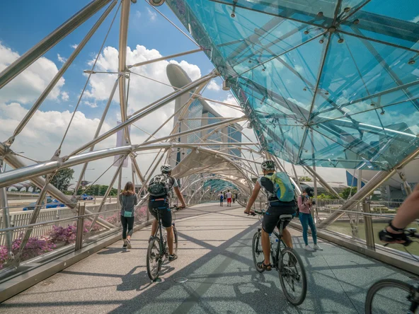 Cycling across modern bridge by Marina Bay, Singapore 