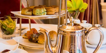 Golden cake stand with cakes and teapot in Raffles hotel 