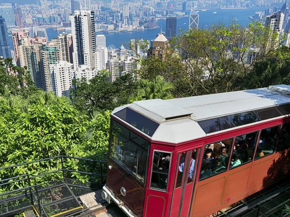Red tram climbing up hillside to Victoria Peak in Hong Kong 