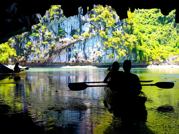 Silhouettes kayaking in Lan Ha Bay, with amazing karst rock background