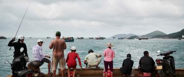 Vietnamese people fishing at a harbour in Con Dao