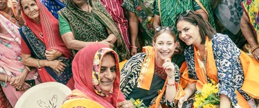 Tourists being welcomed into a photo in India by locals