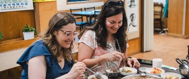 Two competition winners in South Korea eating traditional food