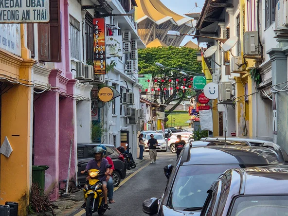 A colourful street in Kuching with a temple in the background