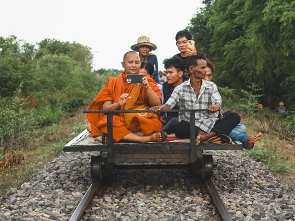 Cambodia Battambang Monk Bamboo Train with a monk taking a photo on his phone