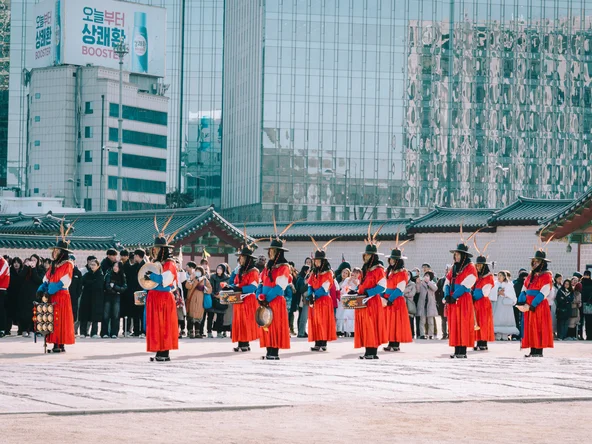 Changing of the guard ceremony in Seoul Palace in front of modern skyscraper buildings