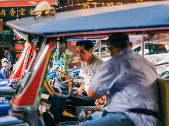 Two men in tuk tuks in Bangkok Thailand