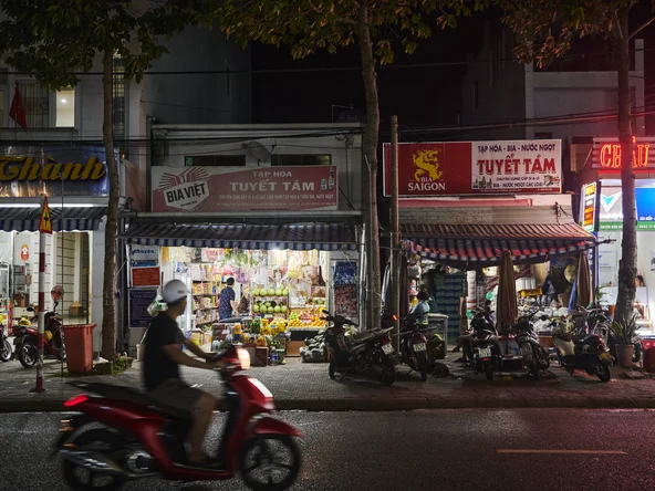 A motorbike whizzing past traditional market stalls in Hanoi, Vietnam