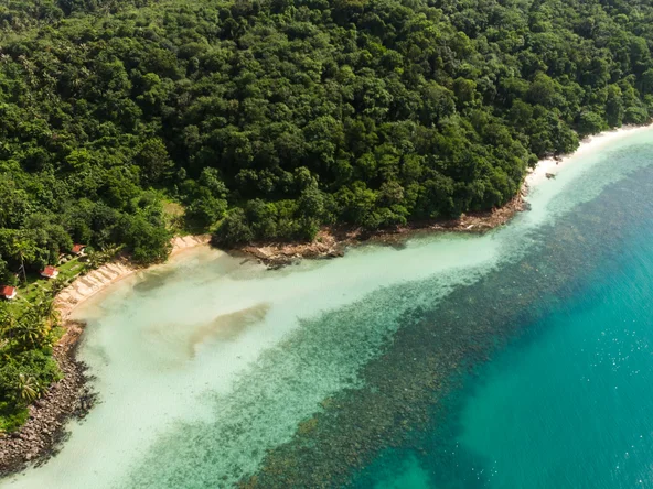 Aerial view of a secluded beach in Ko Chang with crystal clear blue water and jungle