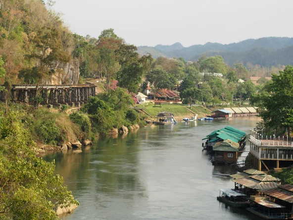 View of KANCHANABURI river bend and abandoned railway with buildings and boats 